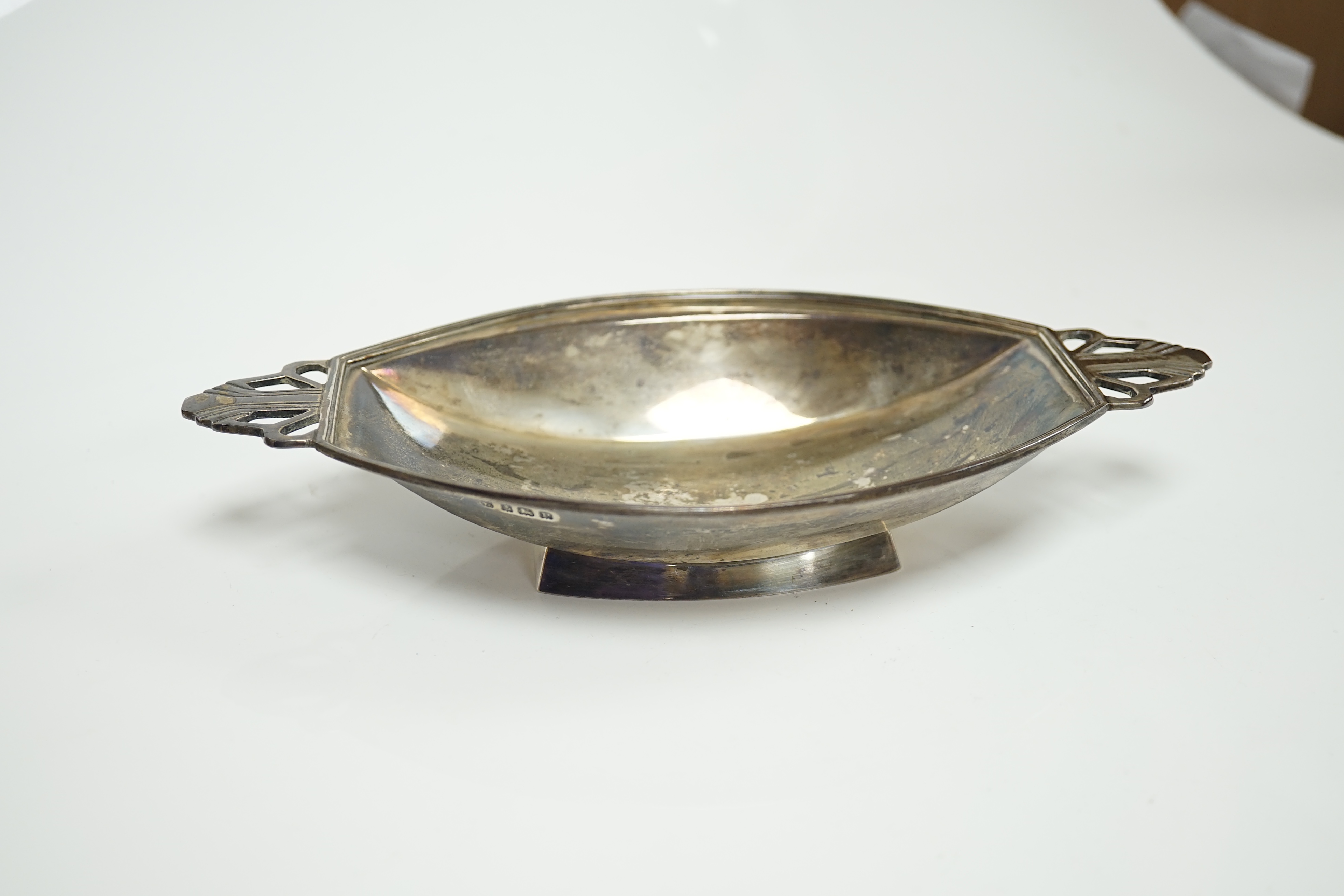 A George VI Art Deco silver two handled dish, Birmingham, 1939, 21.1cm, together with three assorted silver napkin rings, a modern silver sugar caster and a weighted sterling tazza. Condition - poor to fair